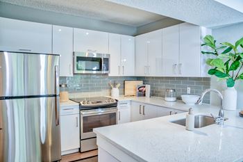 Well-appointed Kitchen with Quartz Countertops & Glass Backsplash at The Sophia at Abacoa, Jupiter